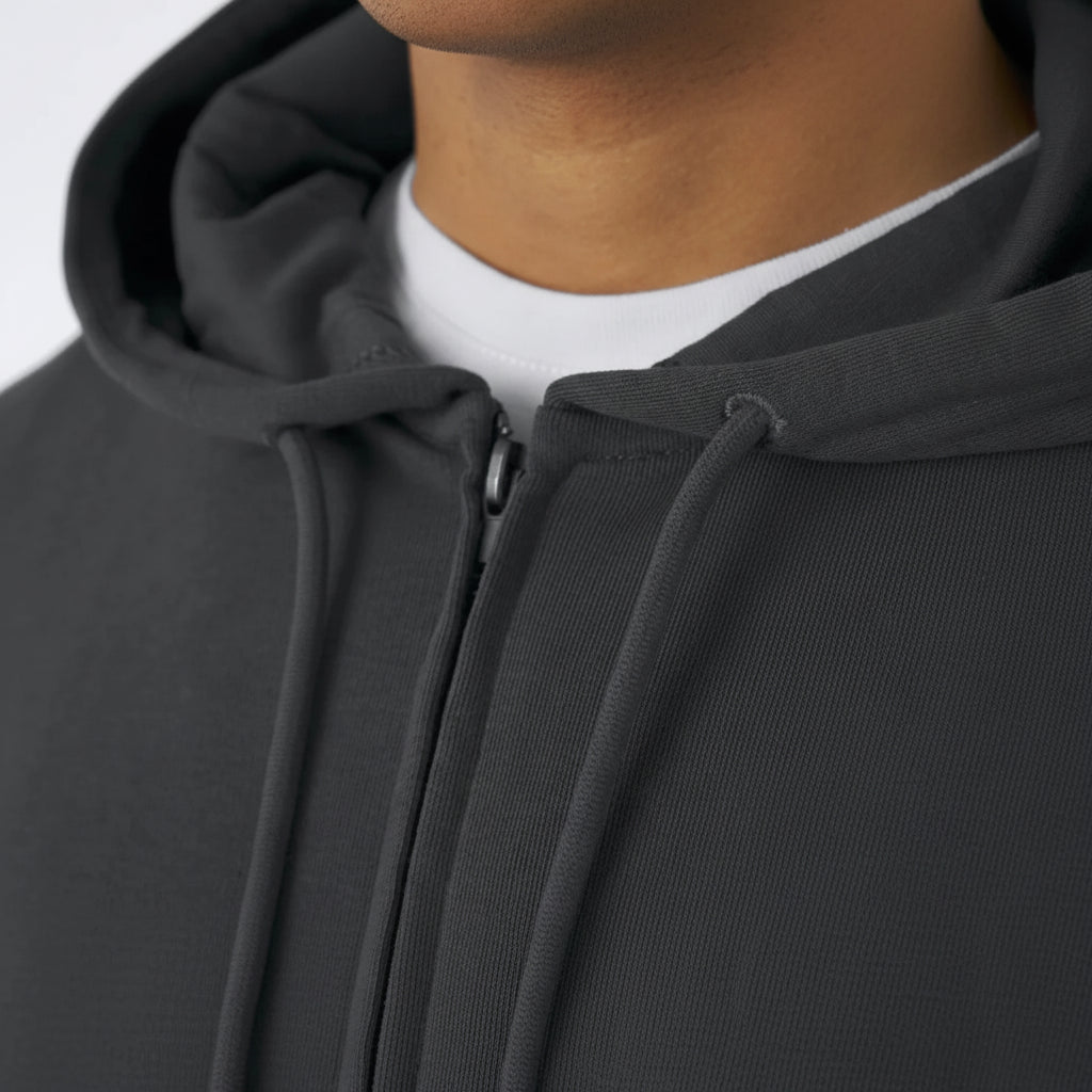 Close-up of a dark gray hoodie with a zipper, worn by a person.