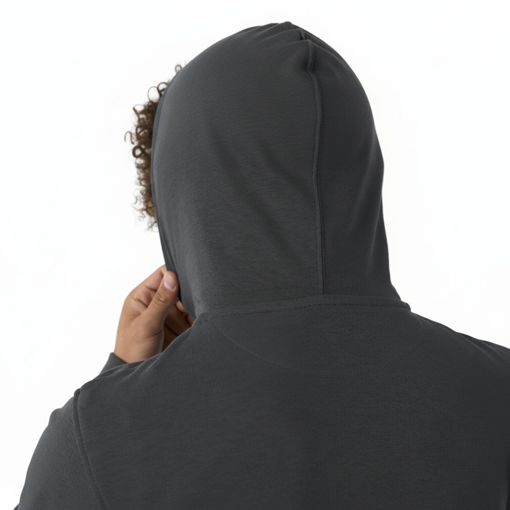 Person wearing a dark gray hoodie with the hood up on a white background