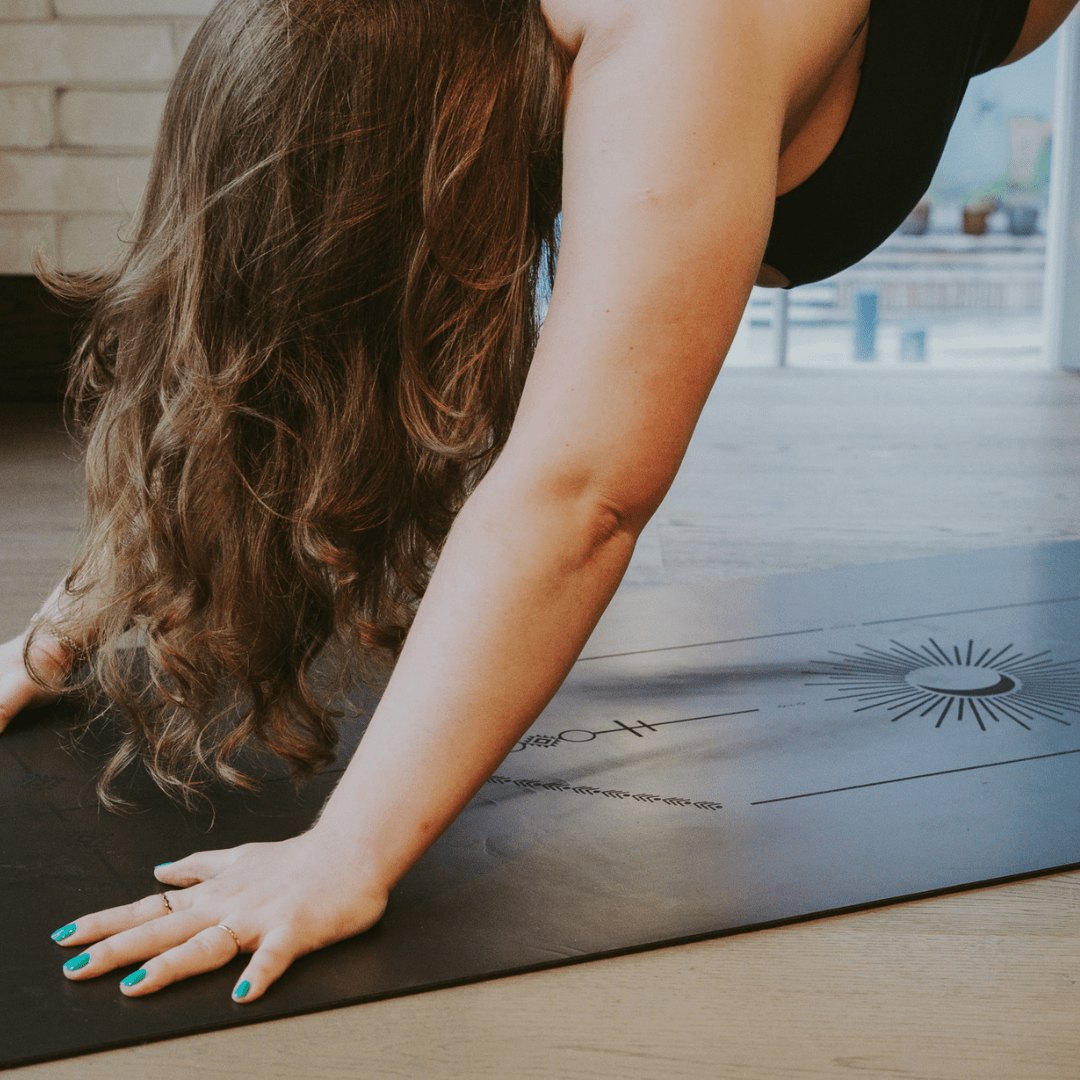 Person practicing yoga on a mat with a blurred background