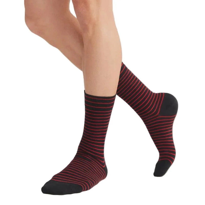 Red and black striped socks worn by a person on a white background