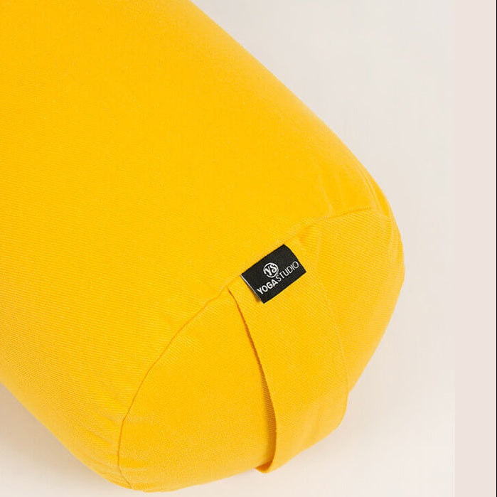 Yellow yoga bolster with a brand logo on a light background