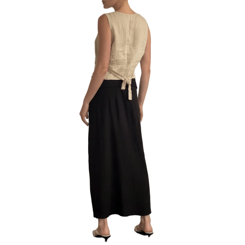 Woman wearing a beige top and black skirt on a white background