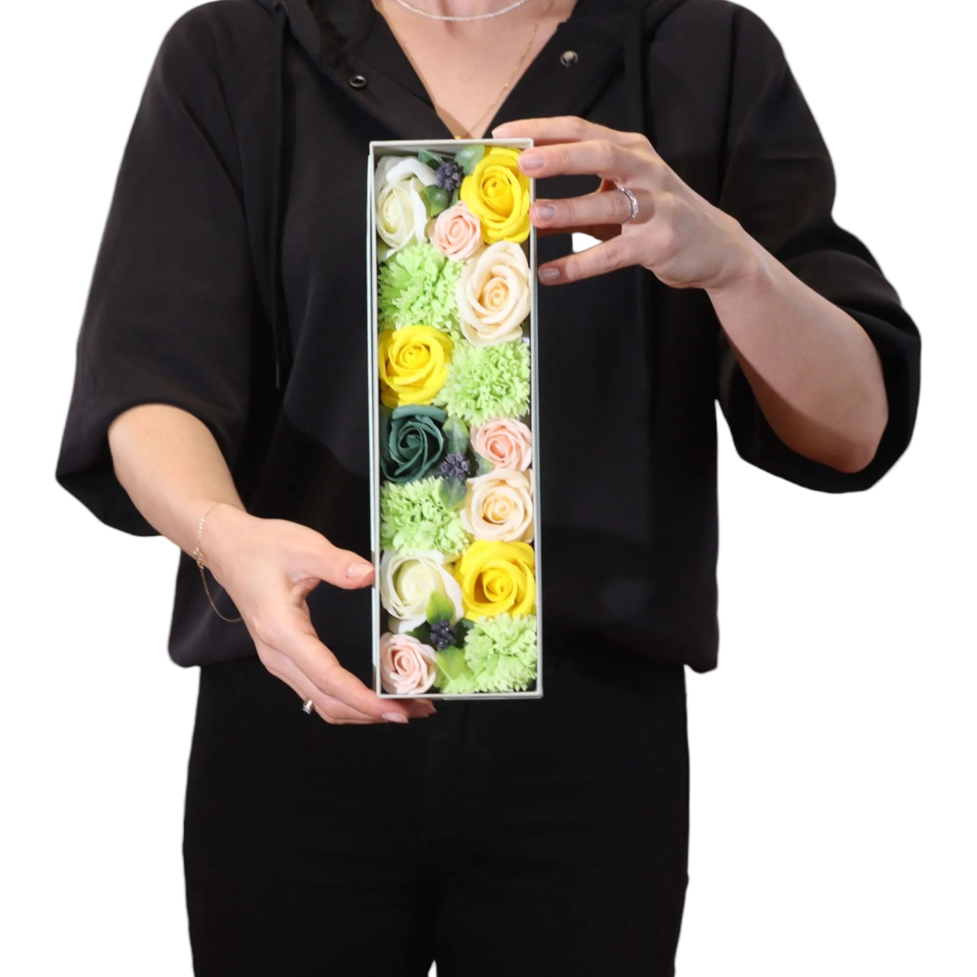 Person holding a rectangular box with  soap flowers against a white background