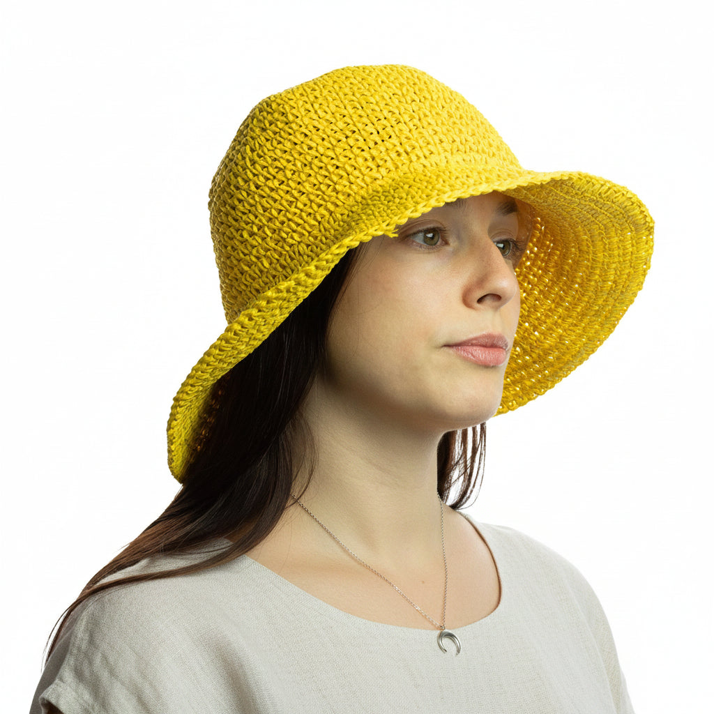 Woman wearing a yellow floppy straw hat on a white background