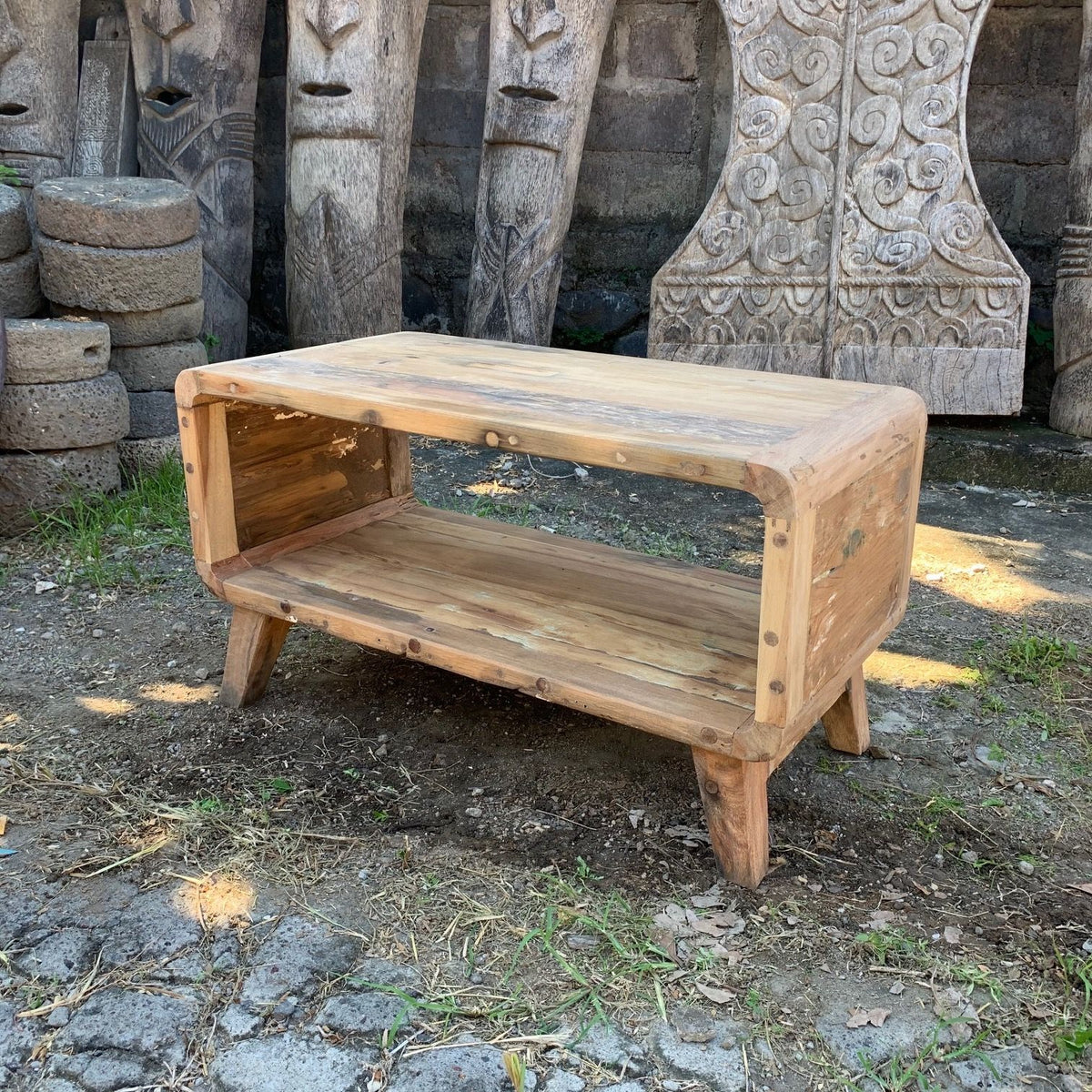Recycled teak coffee table with rounded corners and an open lower shelf, photographed outdoors