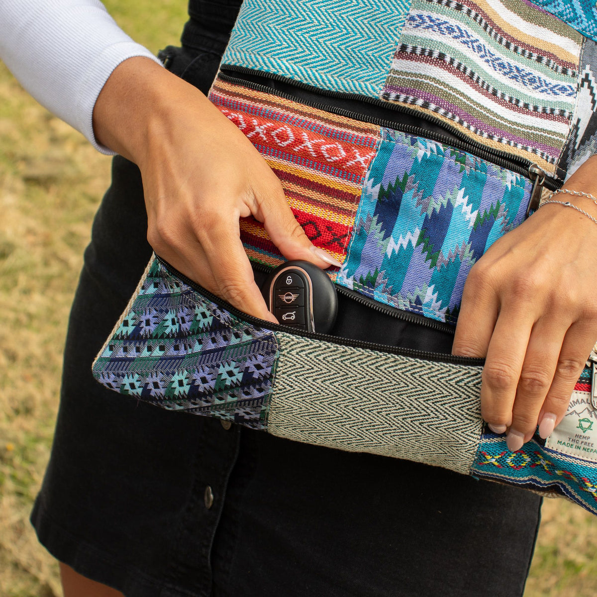 Person placing keys into an exterior zip pocket on the Kathmandu patchwork tote