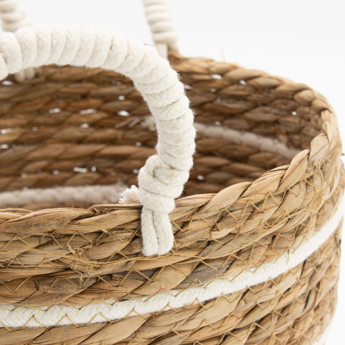 Close-up of a white wrapped loop handle attached to the woven basket rim