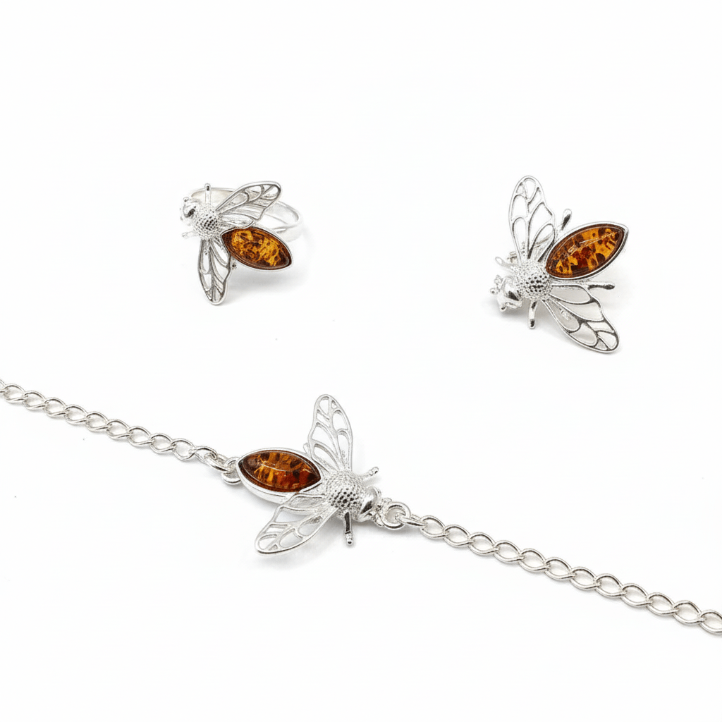 Bee-shaped silver jewellery set with amber stones on a white background