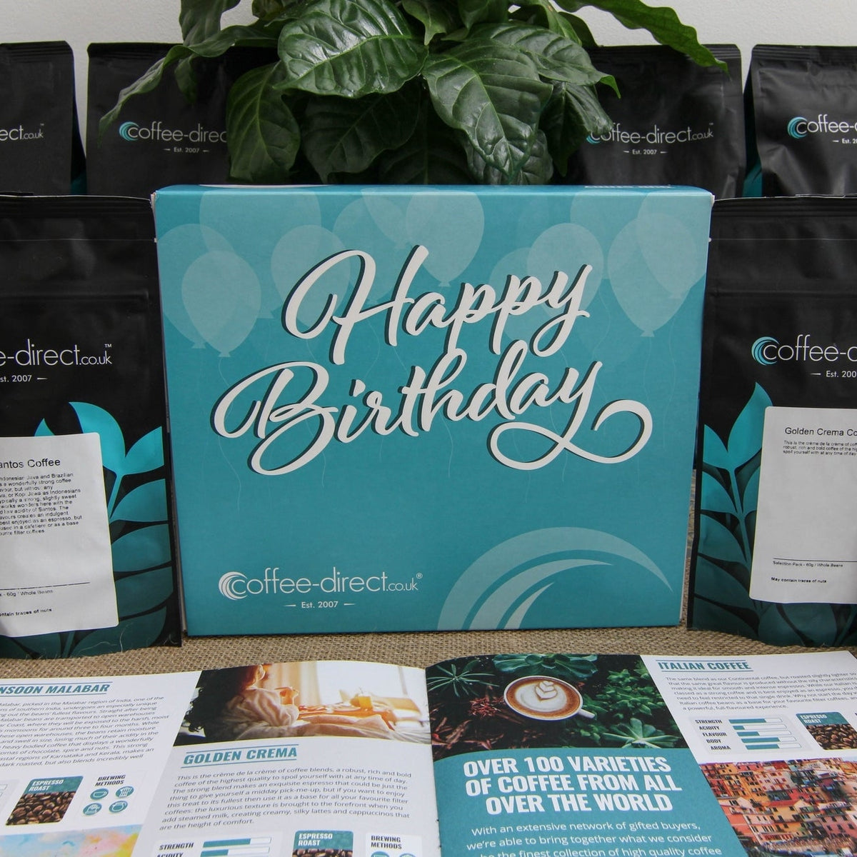 Happy Birthday coffee gift box surrounded by coffee pouches with an open coffee guide