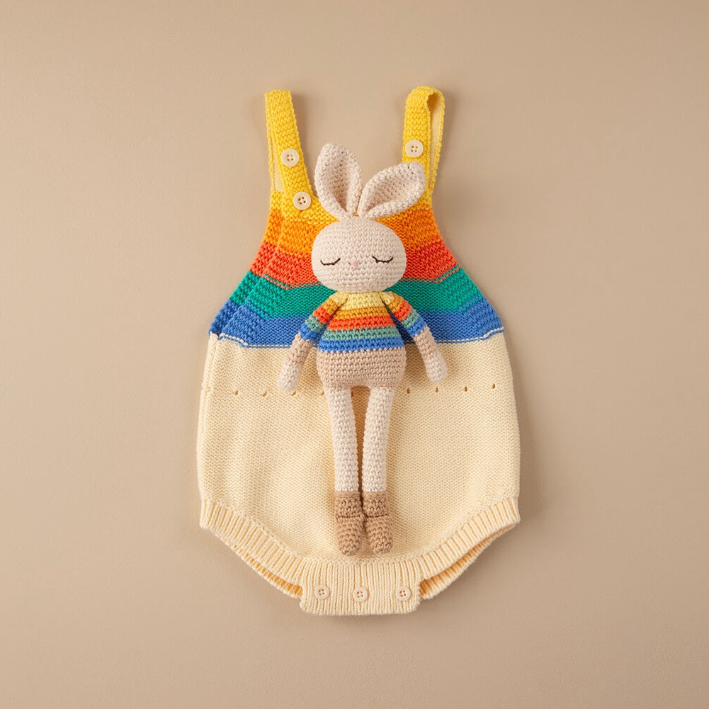 Bonnie Bunny rainbow crochet toy displayed on coordinating rainbow-striped knitted babywear
