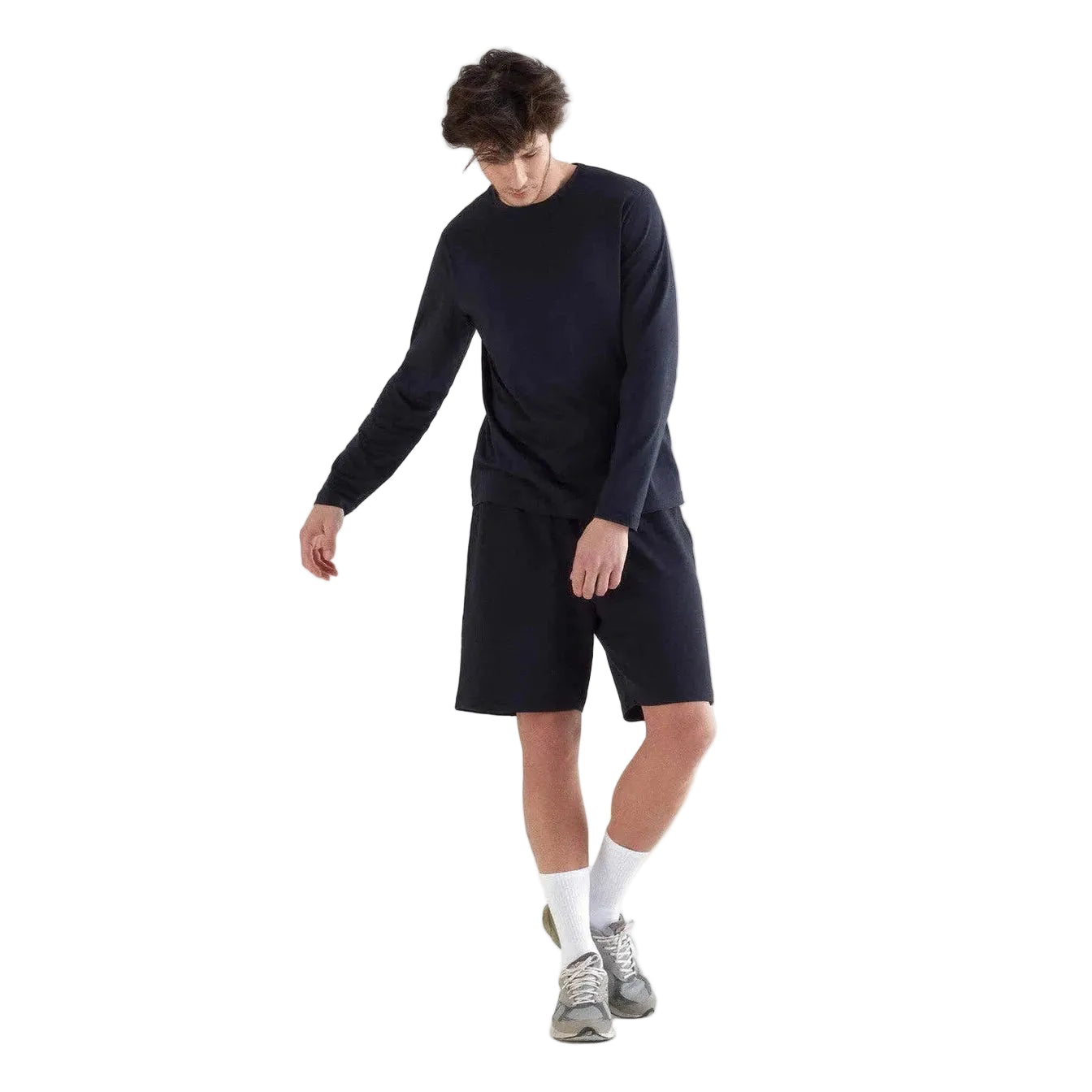 Person wearing a black long-sleeve shirt and shorts on a white background