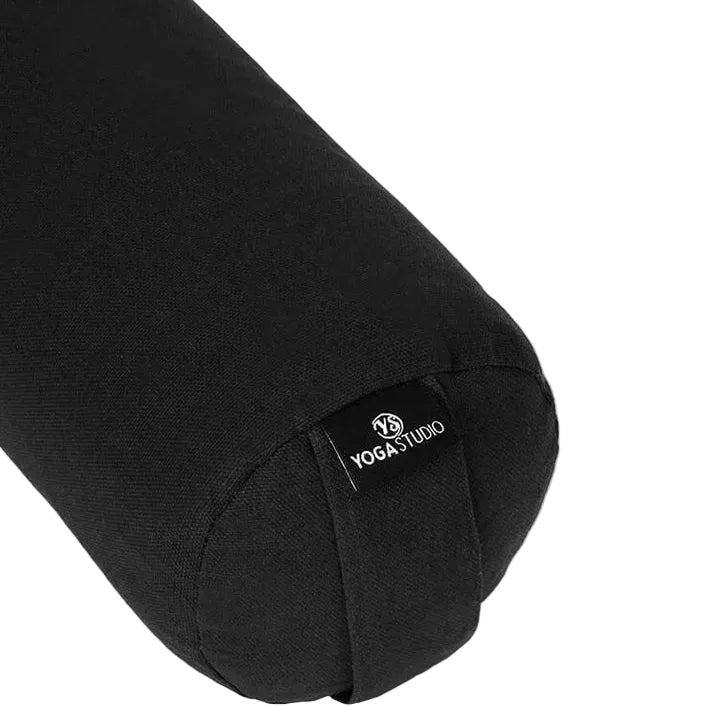 A cylindrical fabric yoga bolster pillow in Black, featuring a small embroidered logo on the side, set against a plain white background.