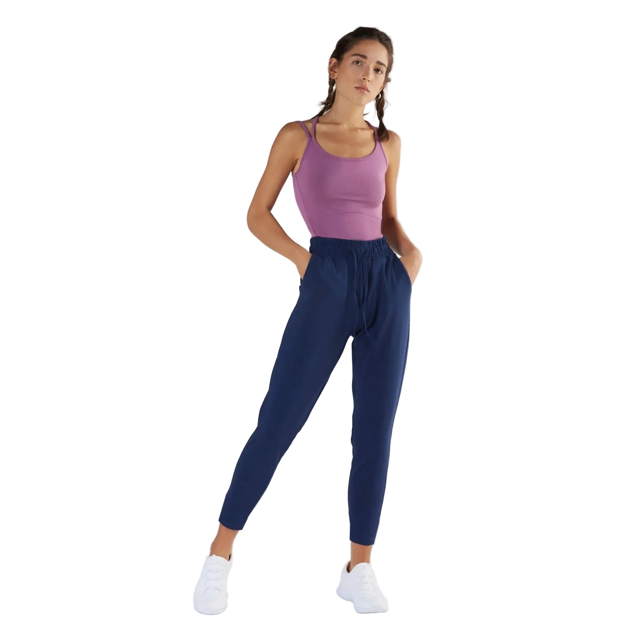 Woman wearing a purple tank top and blue leggings on a white background