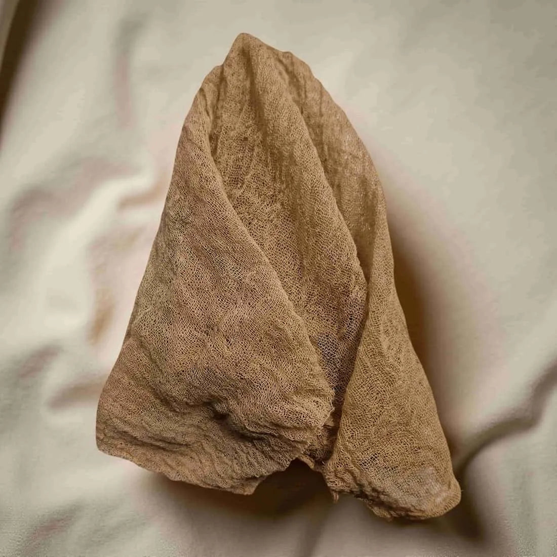 Brown textured fabric gift wrap on a beige surface