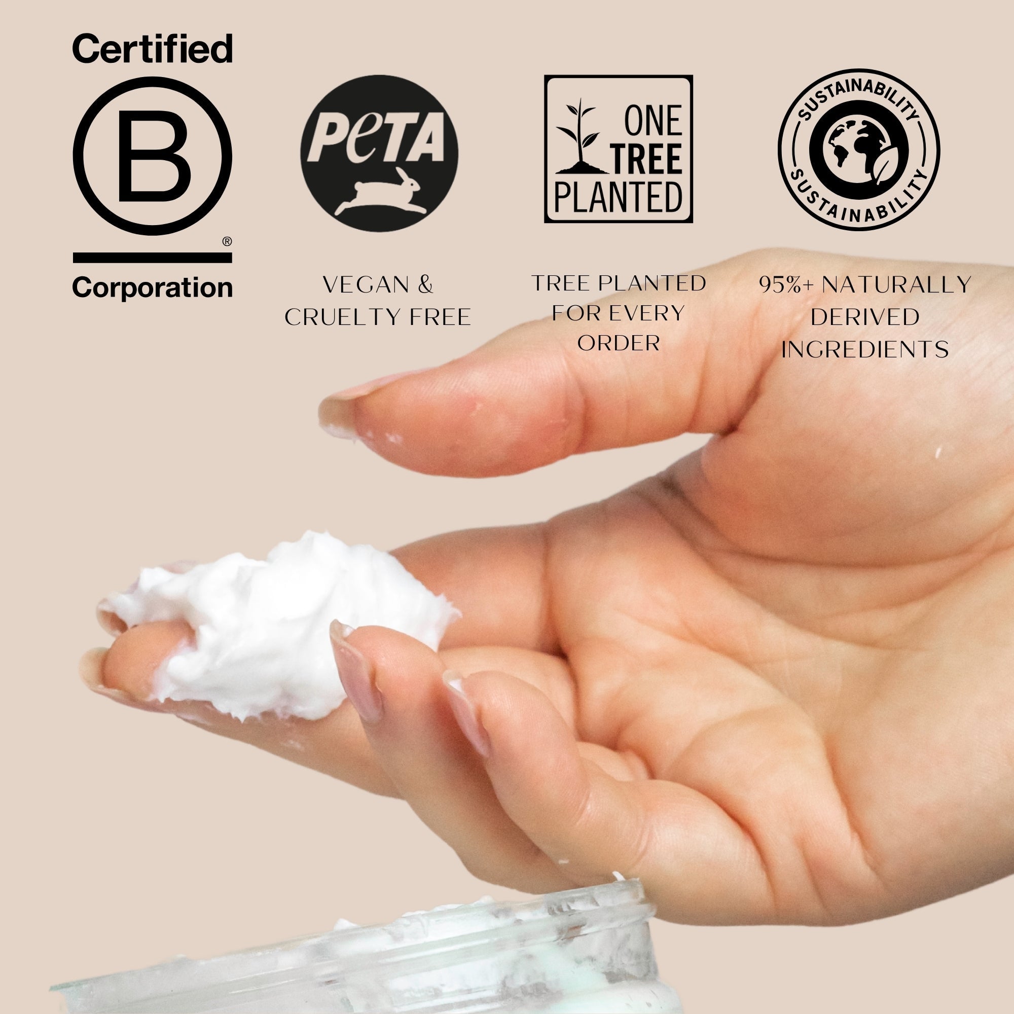 Hand holding a small amount of white cream with sustainability certification logos on a beige background