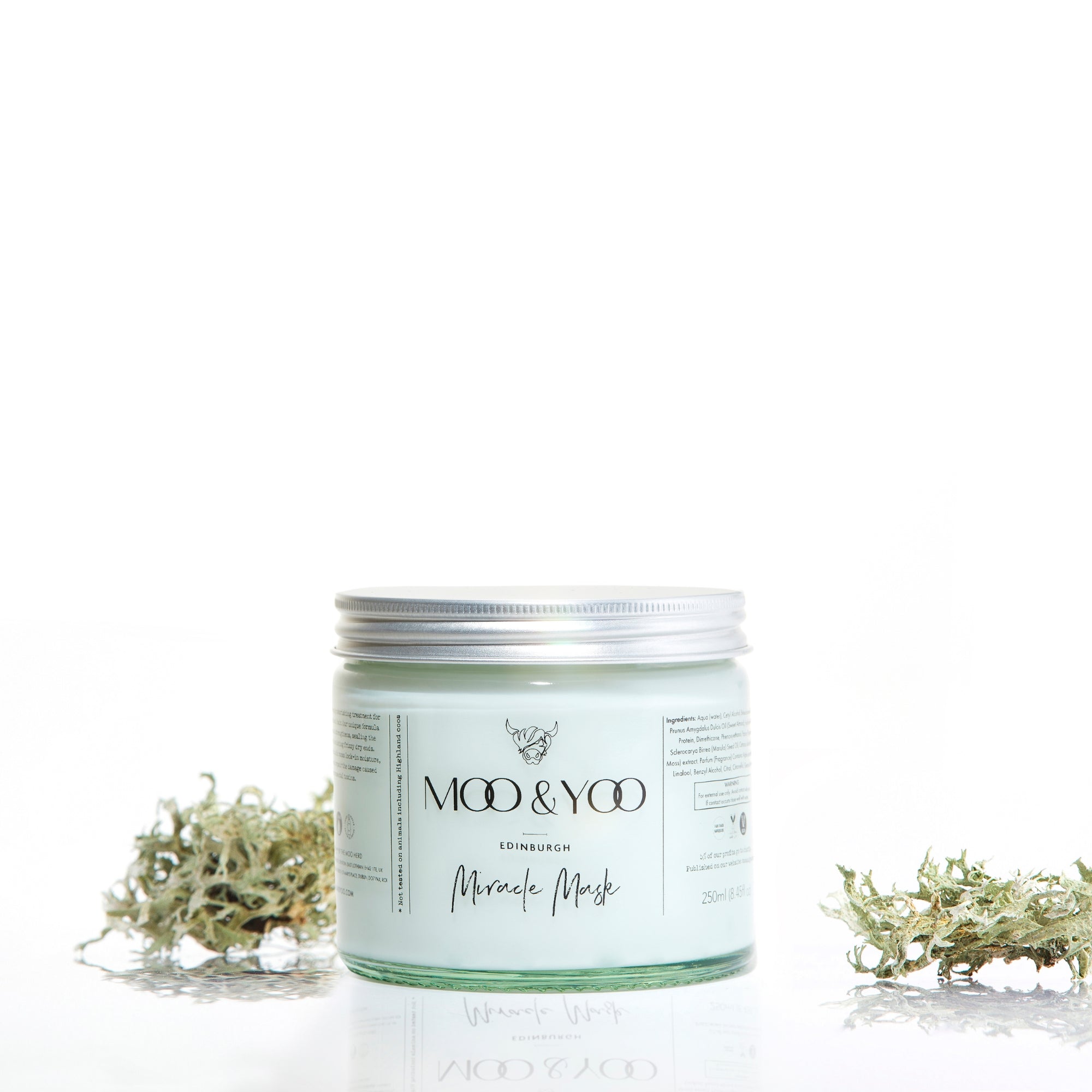 Jar of 'Moo & Yoo' skincare product with dried moss on a white background