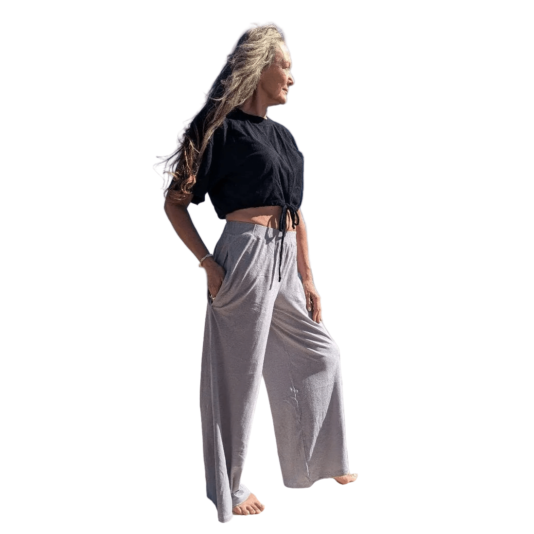 Woman wearing a black top and light grey wide-leg pants on a white background