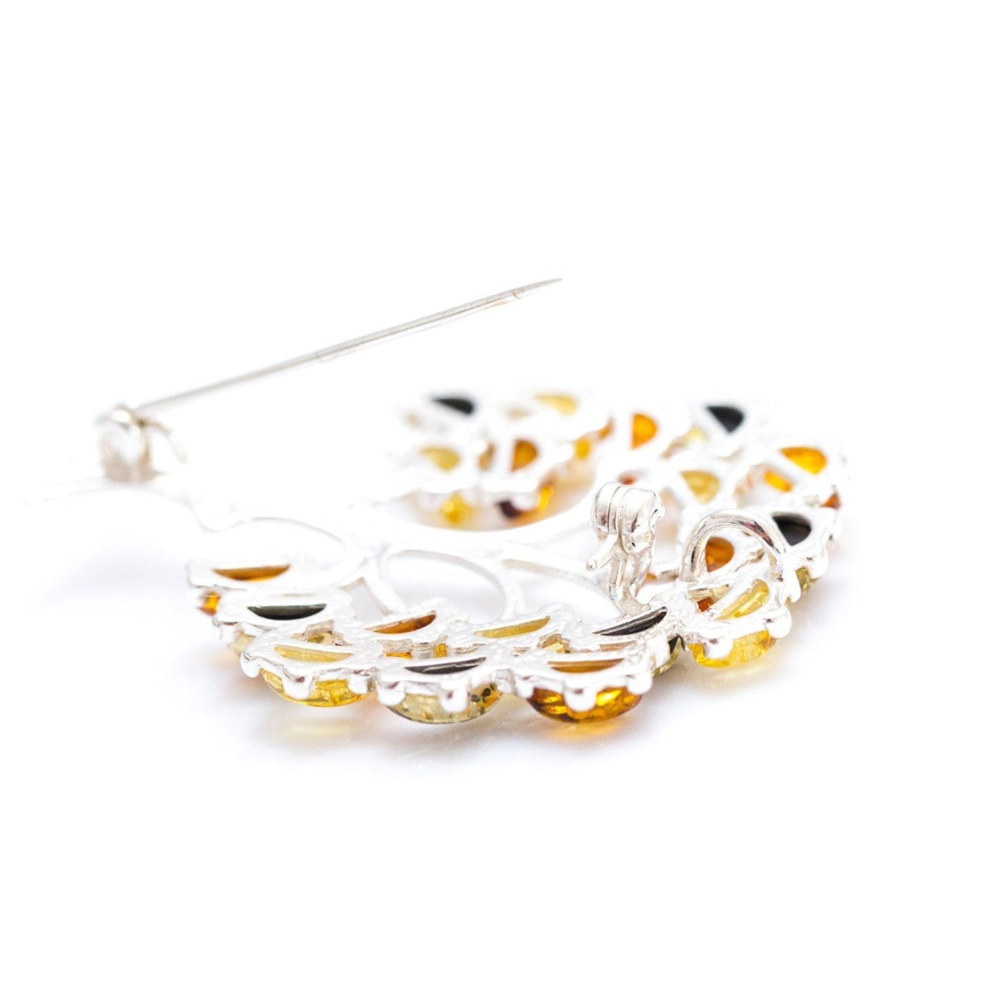 Silver tree brooch on a white background