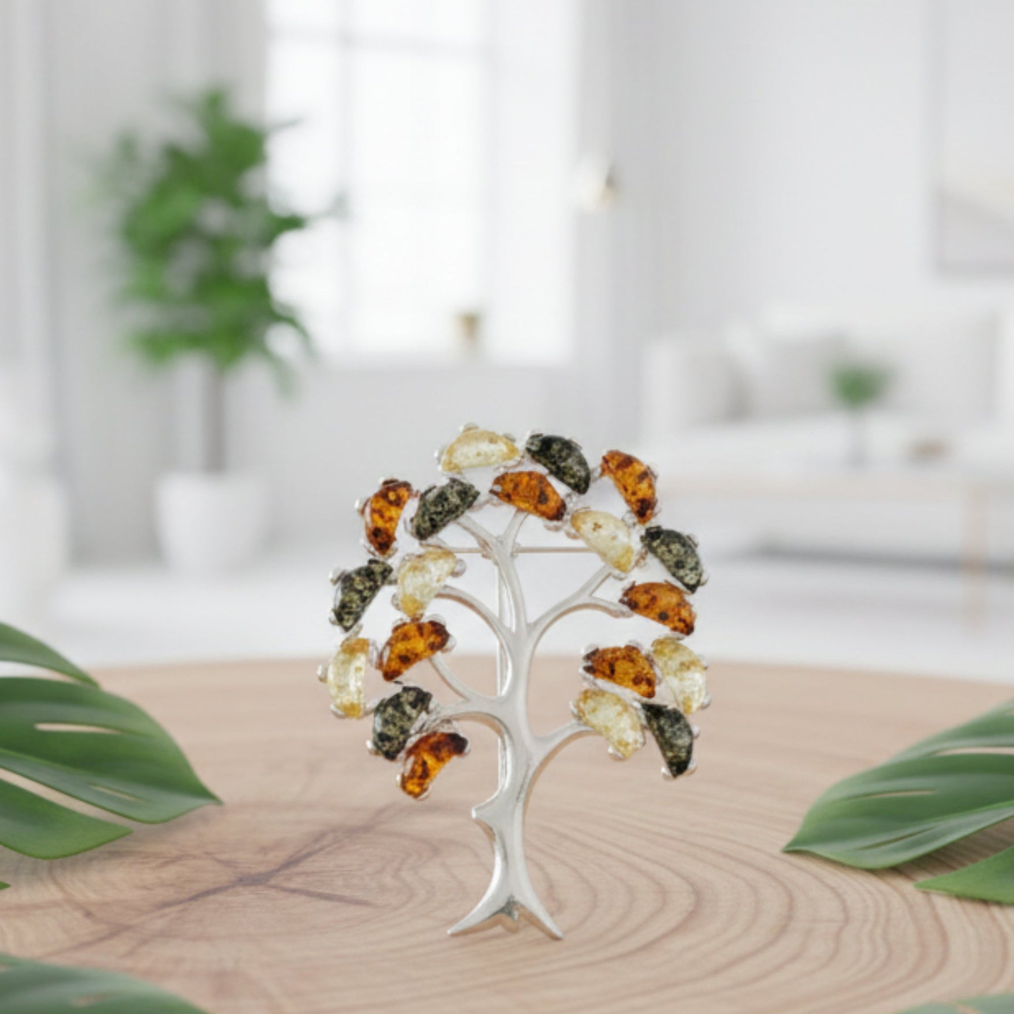 Tree-shaped brooch with colorful stones on a white background