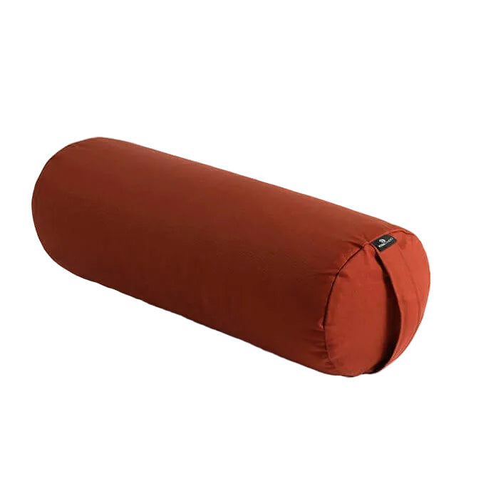 rust coloured cylindrical pillow on a light grey background