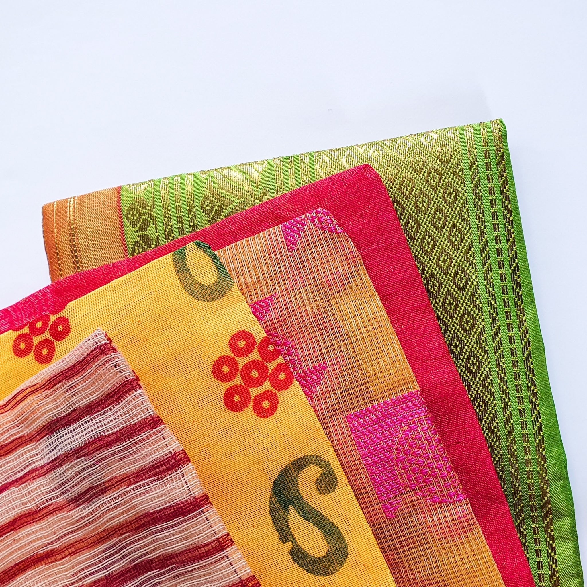 Stack of colorful fabric napkins with patterns on a light blue background