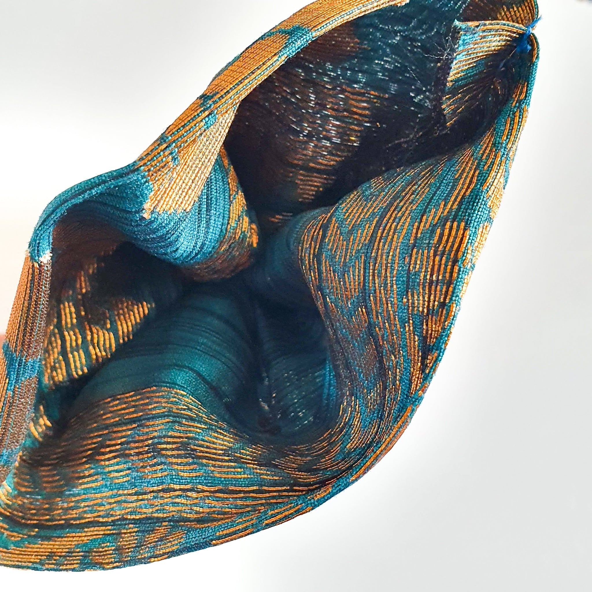 Close-up of a textured fabric with blue and gold patterns on a white background