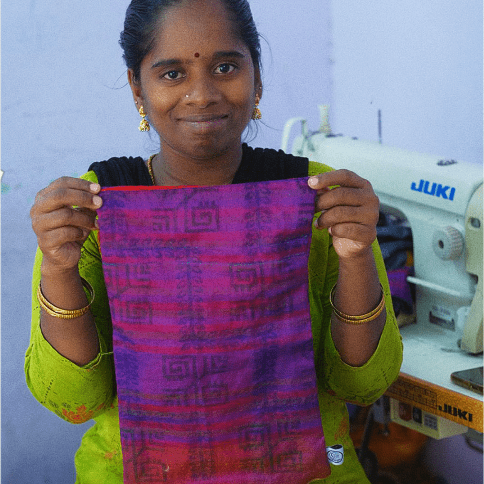 Woman holding a piece of fabric in front of a sewing machine
