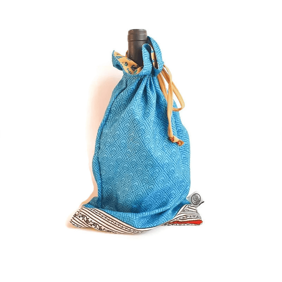 Blue drawstring bag with a pattern holding a bottle on a white background
