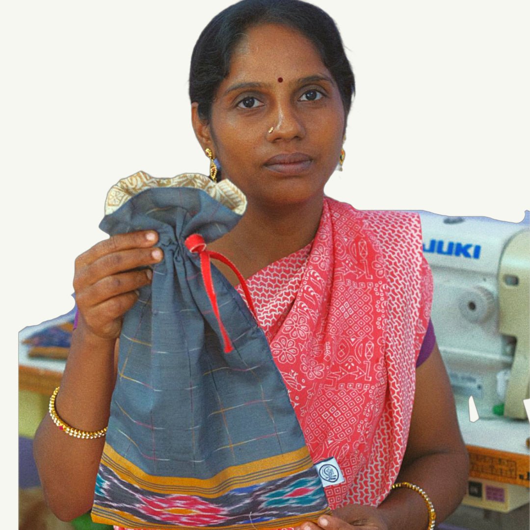 Woman holding a blue fabric pouch with a sewing machine in the background