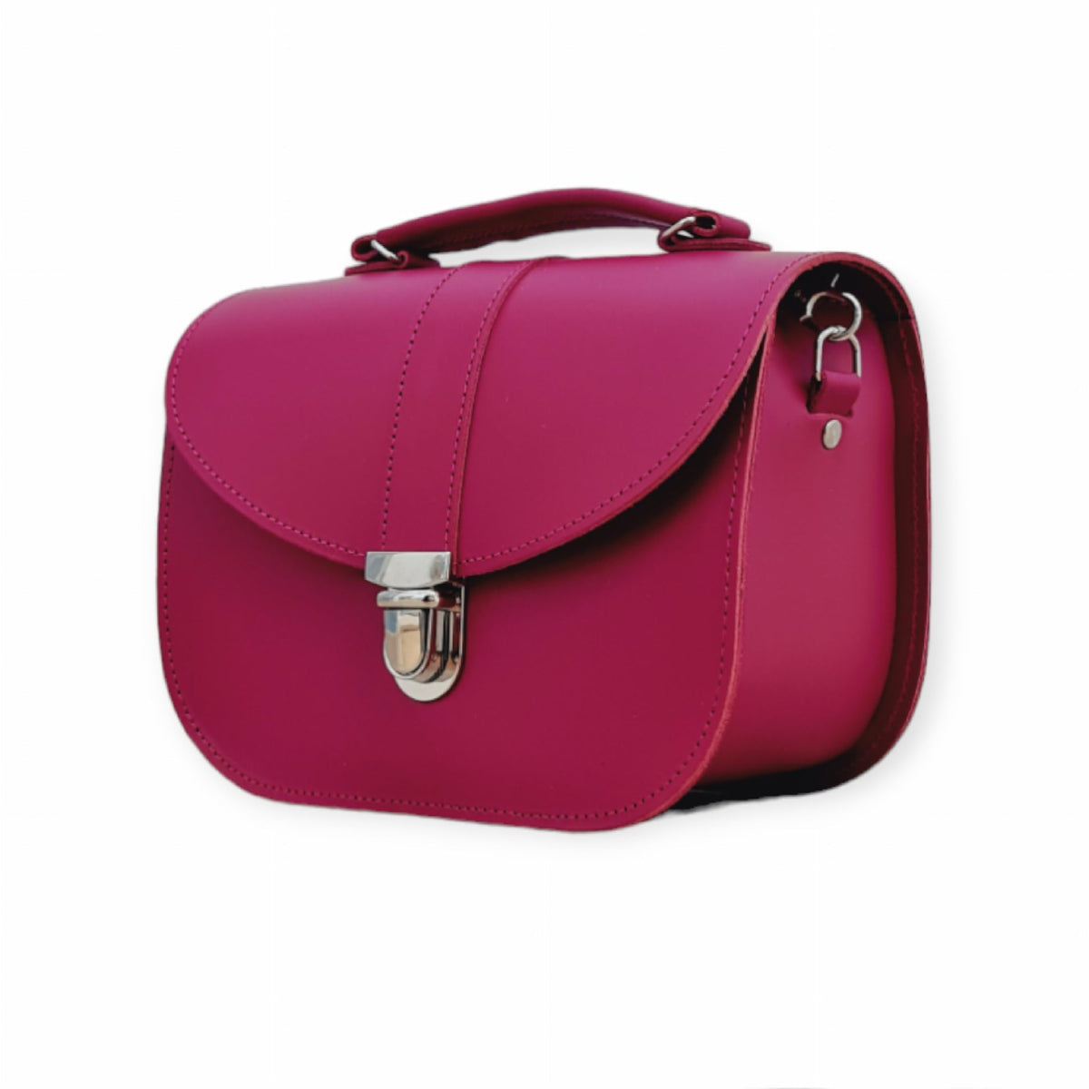 Three-quarter view of the magenta Zatchels Olympia handbag showing its curved flap, top handle and side strap attachment