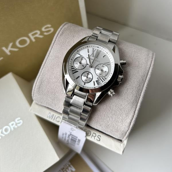 Silver watch on a Kors branded cushion with box in the background