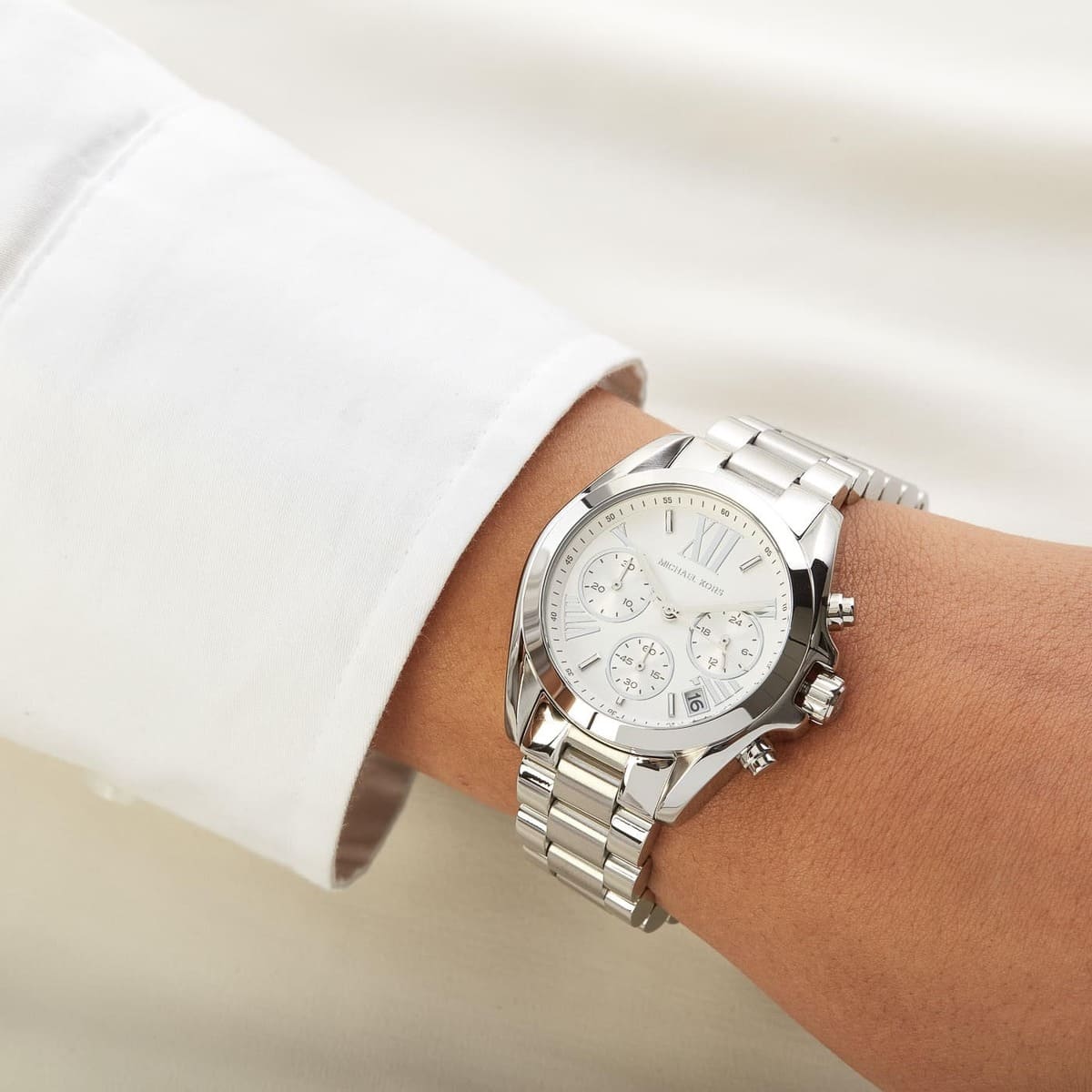 Silver wristwatch on a person's wrist with a light background