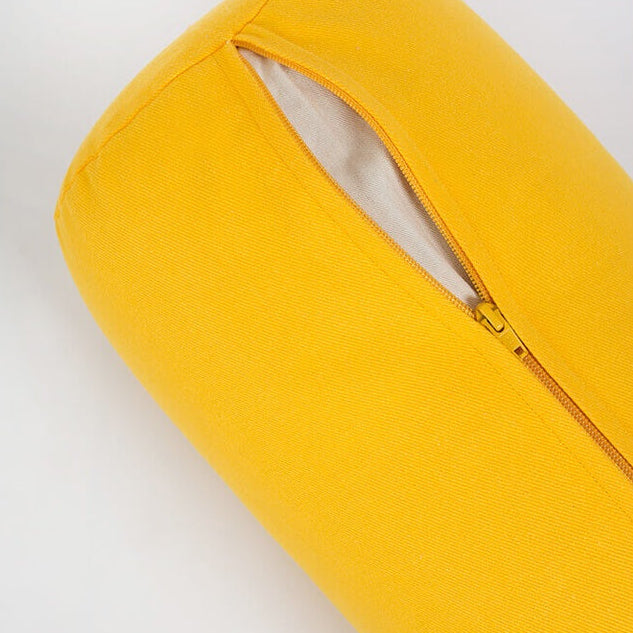 Yellow cylindrical pillow with a zipper on a light gray background