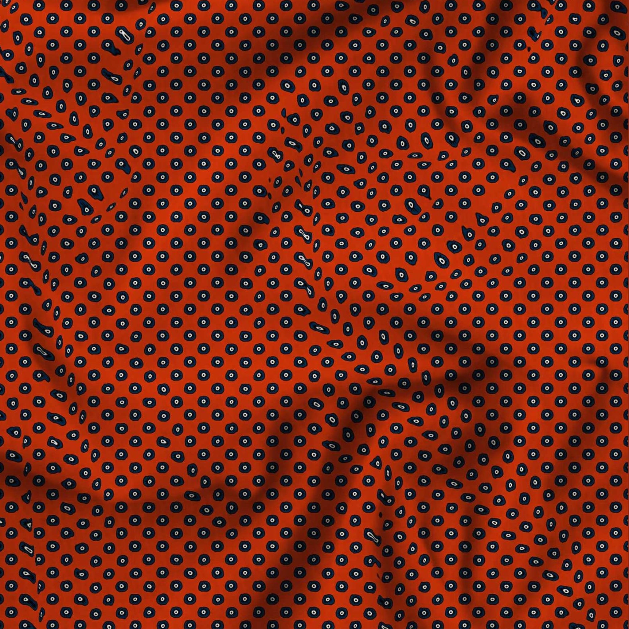 Textured fabric with a navy blue pattern on a red background 