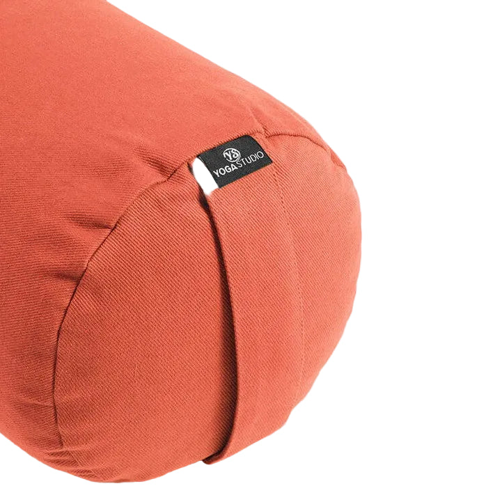 Orange yoga bolster with a visible brand label on a light gray background
