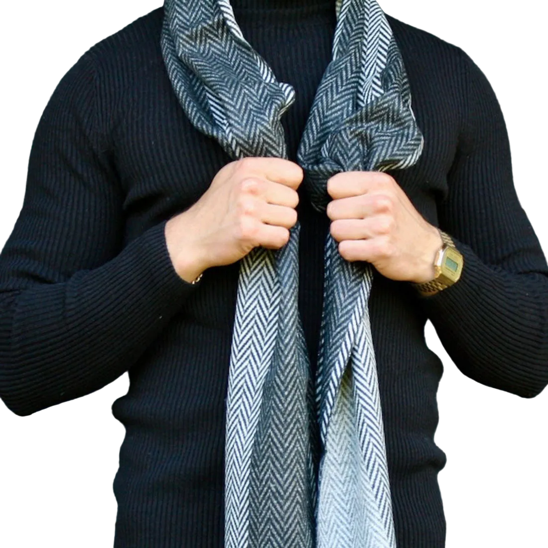 A person wearing a black ribbed knit sweater and a gray and white herringbone pattern scarf, adjusting the scarf with both hands against a plain white background.
