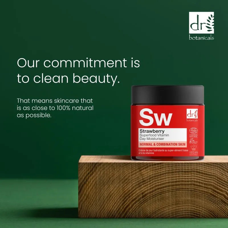 Dr. Botanicals strawberry skincare product on a wooden block with a green background and brand logo.