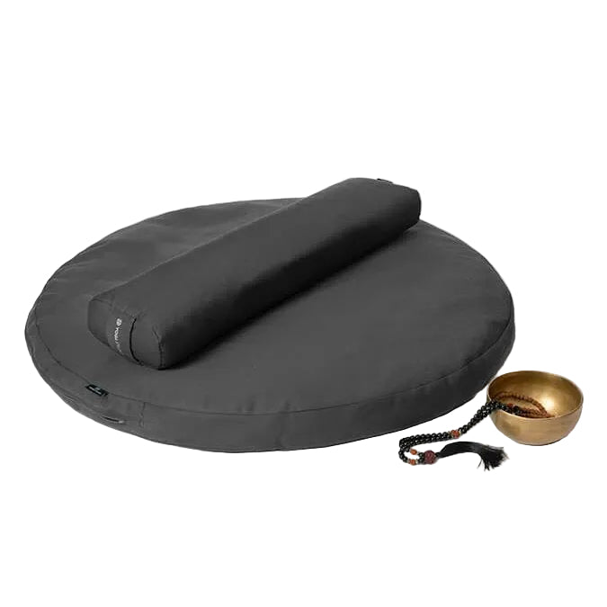 Grey meditation cushion with a cylindrical pillow and gold bowl on a white background