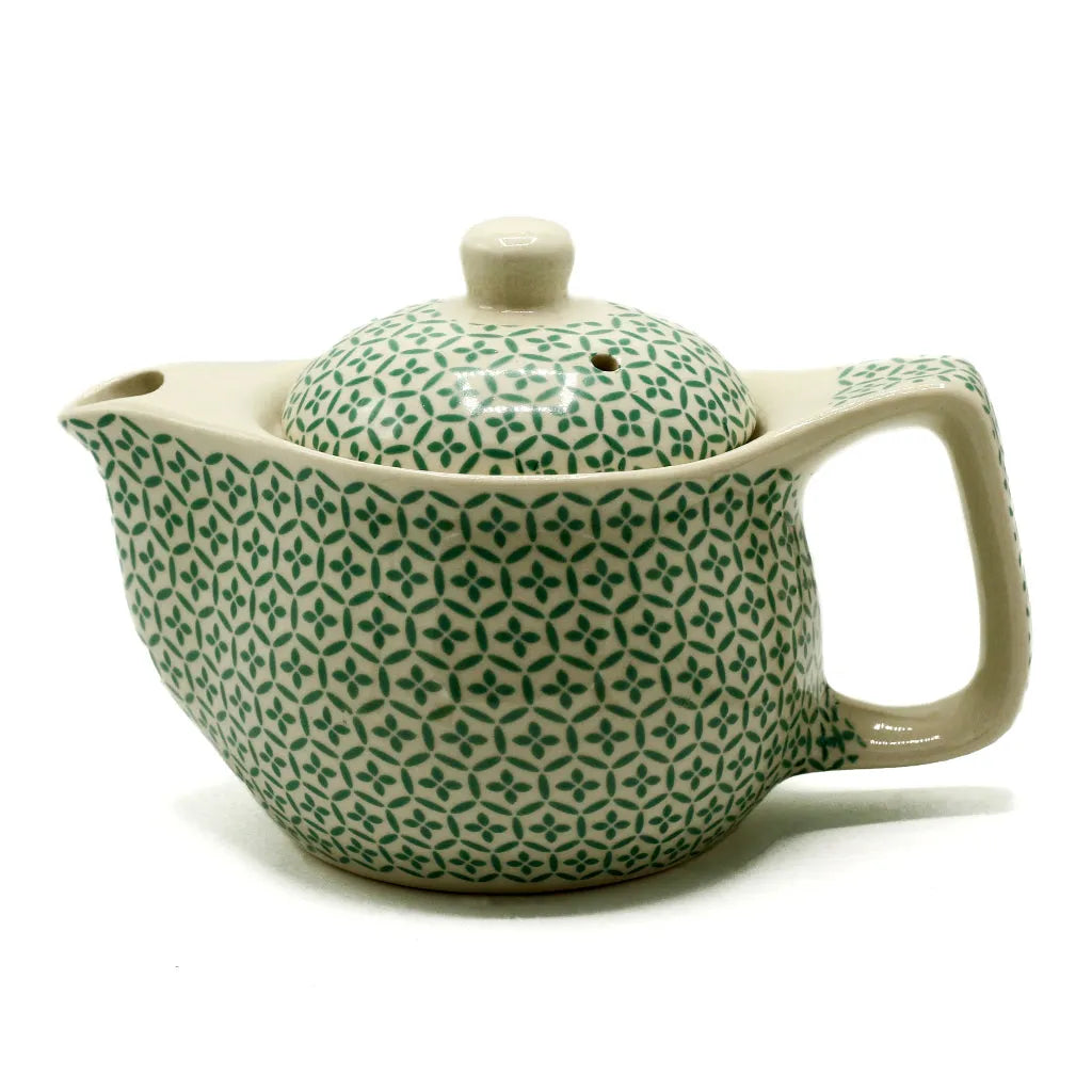 Ceramic teapot with green geometric pattern on a white background