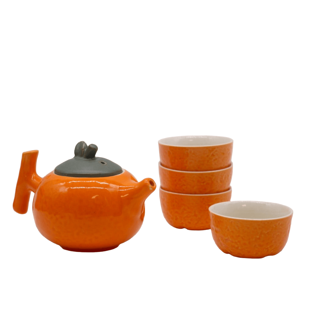 Emmy Jane - Herbal Teapot Set - Orange Teapot & Four Cups. This charming set features a teapot shaped like a plump orange and four matching cups with a textured orange peel design. The vibrant design and compact size make it the perfect gift.