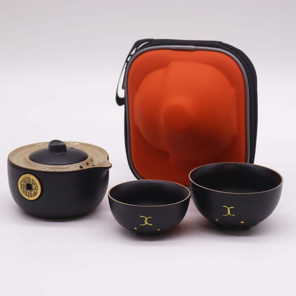 Emmy Jane -T ravel Teapot Set for 2 - Money Cat Teapot Set - Black or Red. Add a touch of charm and elegance to your travels.  This delightful Money Cat Teapot Set features a uniquely designed teapot and two matching cups, all neatly packed in a stylish travel case, perfect for tea lovers on the go. The teapot features a sleek black finish adorned with a golden money design, symbolizing prosperity and good fortune.