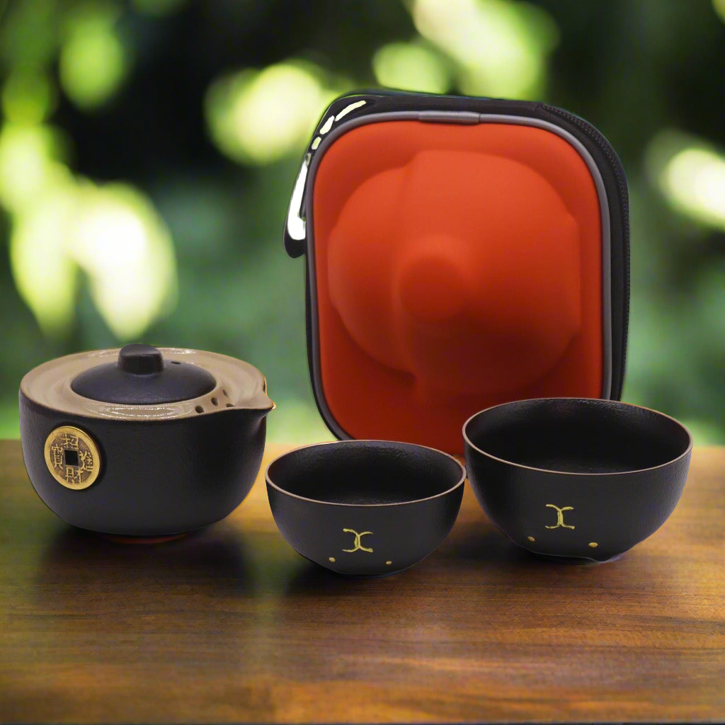 Emmy Jane -T ravel Teapot Set for 2 - Money Cat Teapot Set - Black or Red. Add a touch of charm and elegance to your travels. This delightful Money Cat Teapot Set features a uniquely designed teapot and two matching cups, all neatly packed in a stylish travel case, perfect for tea lovers on the go. The teapot features a sleek black finish adorned with a golden money design, symbolizing prosperity and good fortune.