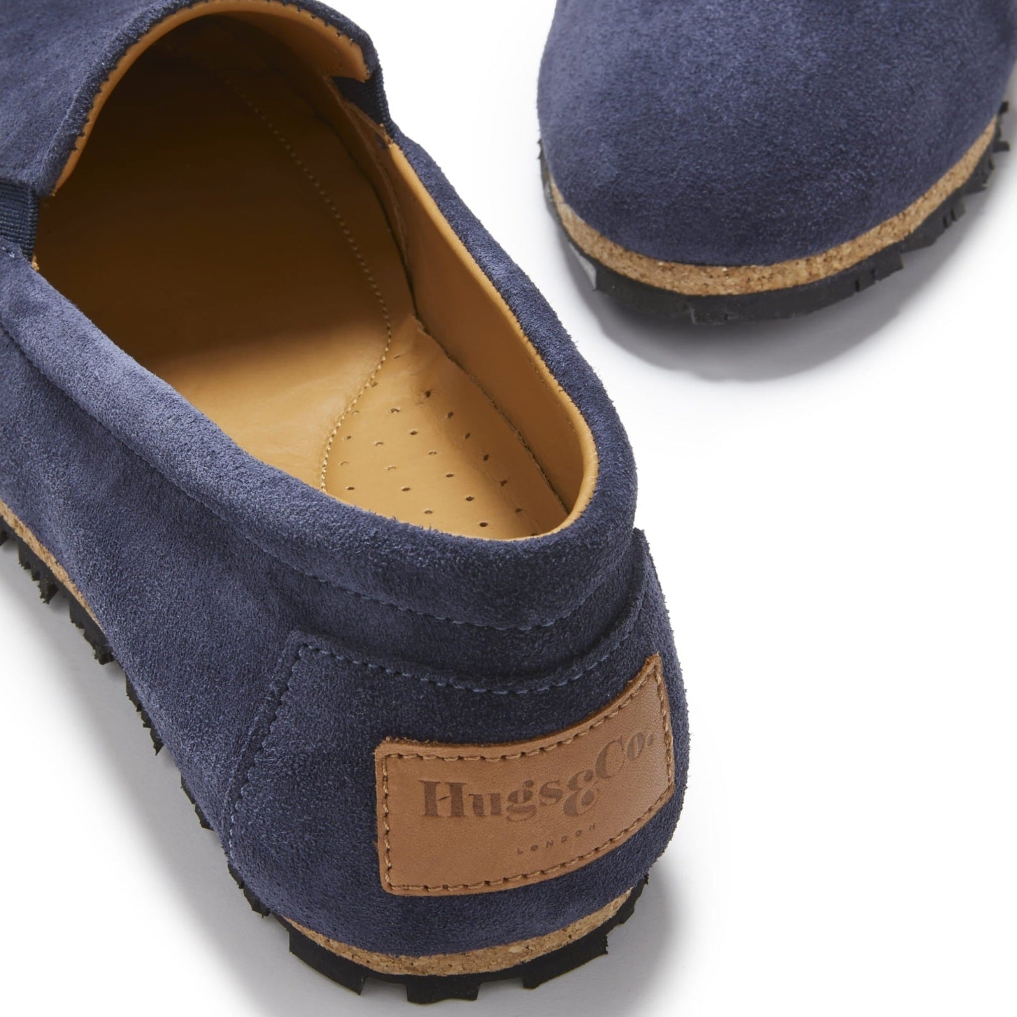 Blue suede loafers with brown soles and visible brand logo on a white background