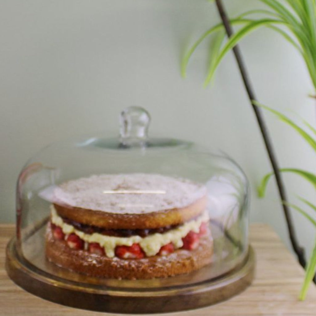 Emmy Jane Boutique Mango Wood Cake Stand With Glass Dome. A high-quality, solid wood cake stand with a glass dome, a beautiful addition to our Country Cottage range of products. Display and keep fresh your home baking in style. Can house a 10" wide cake, up to 3.5" in height. Perfect for your Easter or Christmas cake.