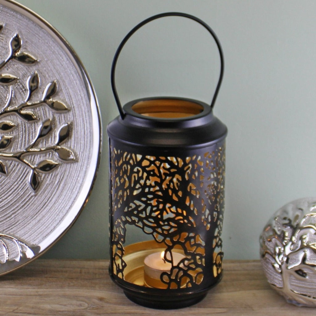 Emmy Jane - Black Candle Lantern - Tree Of Life Design - Black Tealight Candle Holder. A beautiful candle lantern in black with a golden interior featuring our tree of life design cutout around the lantern. Will hold a tealight candle. The lantern is made of 100% iron and features a handle for carrying or hanging. Measurements: 10 x 17 x 10cm.