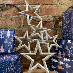 Emmy Jane Boutique - Christmas Stars Decoration - Silver Metal Stars Wooden Base Ornament - 40cm. A metal stacking stars table or hearth decoration. An attractive festive piece suitable for any home. Set on a wooden plinth measuring 15x5.5cm