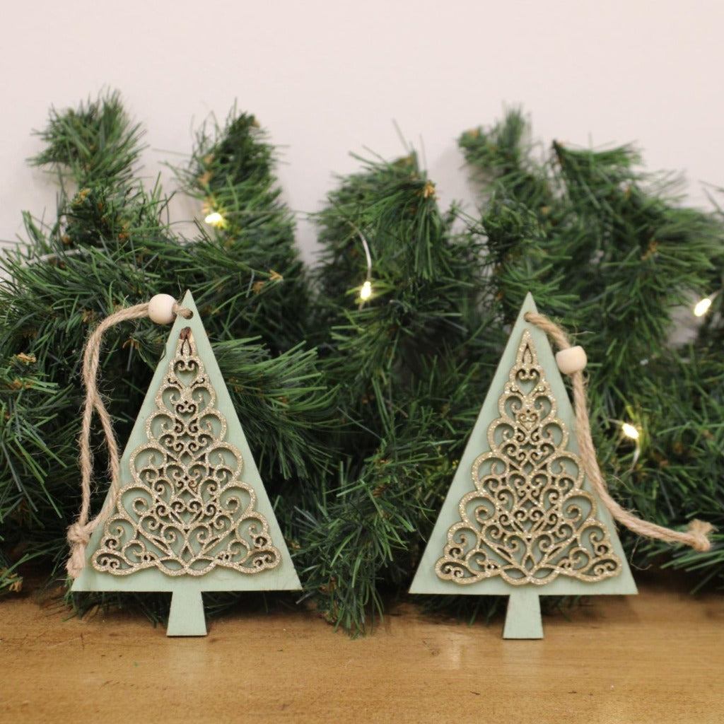 Emmy Jane Boutique - Wooden Christmas Tree Decorations - Pair of Hanging Tree Decorations.A charming pair of wooden hanging tree decorations, in shades of green. Both decorations feature gold tree print decals, complete with a jute hanger.