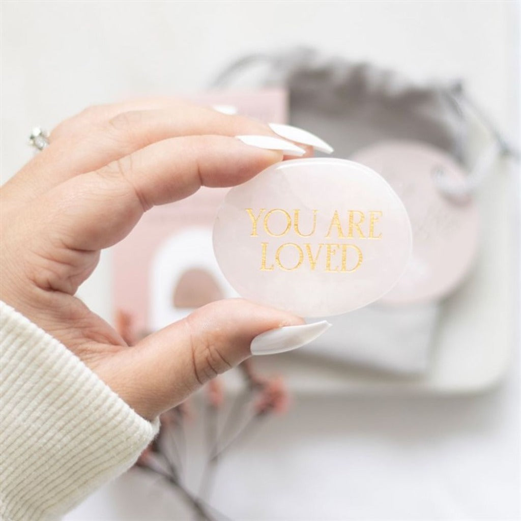 Emmy Jane Boutique - Rose Quartz Crystal Palm Stone - You Are Loved - Romantic Gift for Her. This healing rose quartz palm stone is accented by engraved gold-toned 'you are loved' text, making it a meaningful token of love and care. Presented with an informational insert card and drawstring bag for safekeeping.