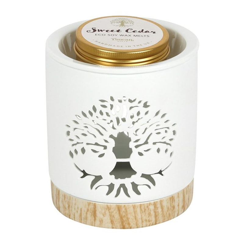 Wax Melts Gift Set - Soy Wax Sweet Cedar - Tree of Life Wax Warmer Gift Set. Fragrance the home with this elegant Tree of Life wax warmer gift set. A white ceramic burner is accented by a wood-effect base and a stunning Tree of Life cut-out design. The set includes a tin of eco soy wax melts in the scent 'Sweet Cedar' that exudes the feeling of forest walks and cabin getaways.