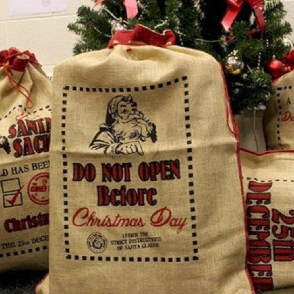 Reusable Christmas Present Bags - Santa Sacks - Natural Xmas Stockings. This wonderfully festive Jute Sack is strong and sturdy. Fill it with presents for your friends and family and also reuse it next year so you can get plenty of use out of it. Made in India. Available in four different designs. Colour Natural Black and Red. Size of the Jute Santa Bag: 76cm x 55cm Size: H: 76 cm; W: 55 cm. Material Jute